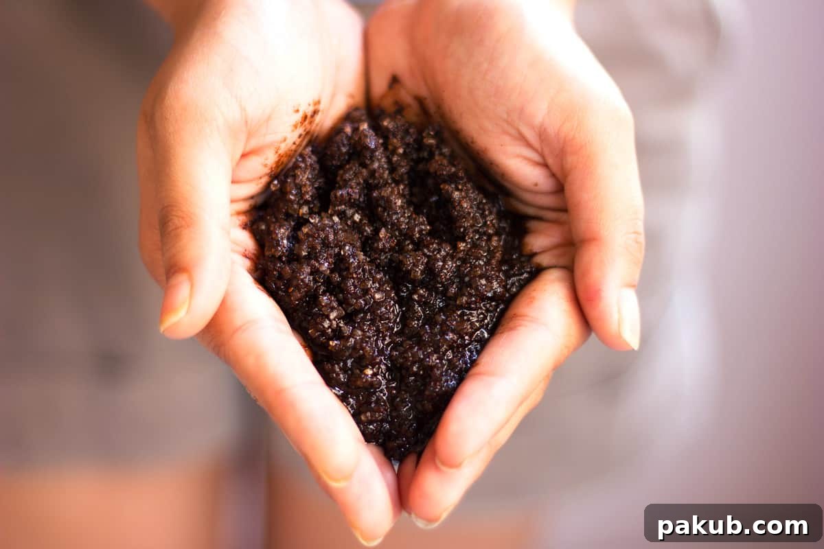 Close-up shot of hands gently applying DIY Homemade Coffee Scrub, highlighting its texture.
