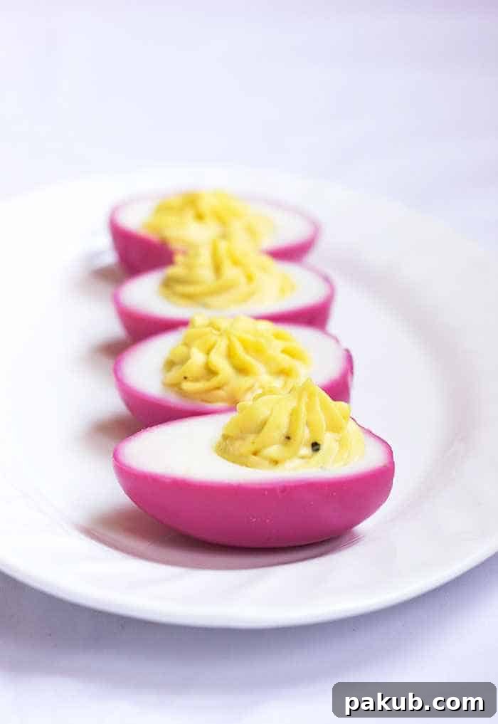 Close-up of pink naturally dyed eggs gracefully arranged on a pristine white plate.