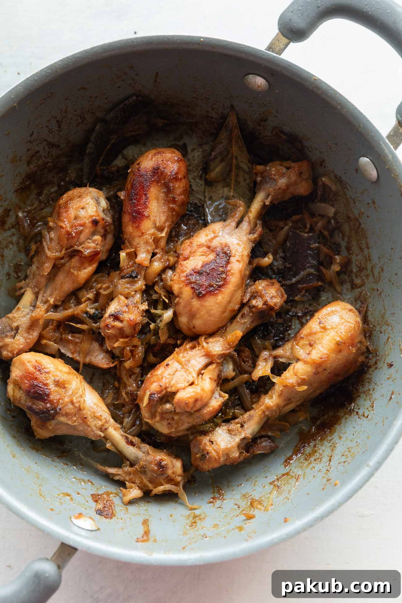 Sweet Onion Roasted Chicken 5 A beautifully plated serving of caramelized onion chicken in a grey pan, garnished with fresh herbs, ready to be enjoyed.