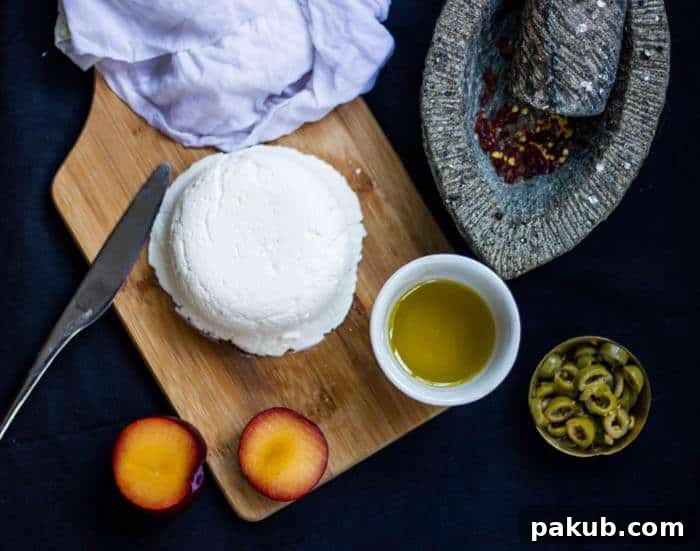 Crafting Delicious Cream Cheese at Home 2 Fresh homemade cream cheese beautifully presented on a rustic wooden board, garnished with fresh herbs and a drizzle of olive oil.
