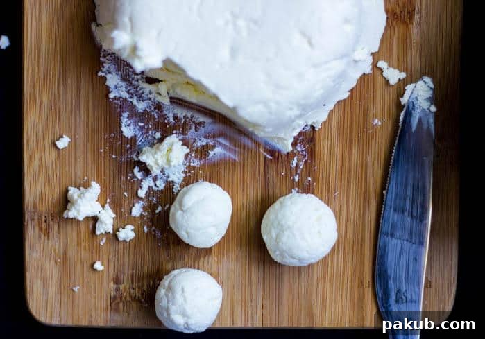 Crafting Delicious Cream Cheese at Home 4 Someone gently stirring a bowl of freshly made homemade cream cheese, showcasing its creamy texture.