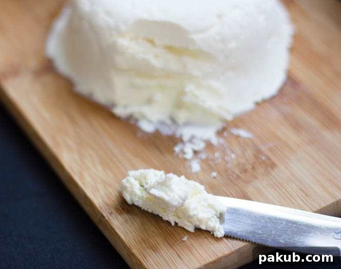 Crafting Delicious Cream Cheese at Home 7 Homemade cream cheese being strained through muslin cloth in a colander, showing the traditional method.