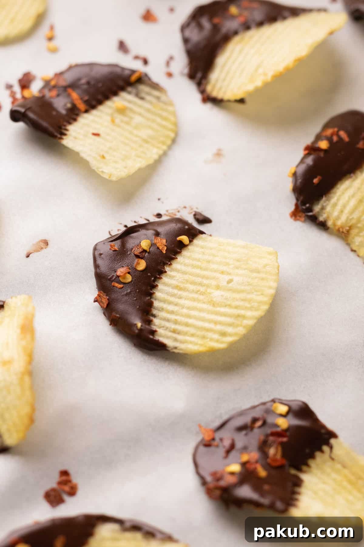 Close-up shot of several Chili Chocolate Covered Potato Chips, perfectly coated and sprinkled with flakes, ready to be enjoyed.