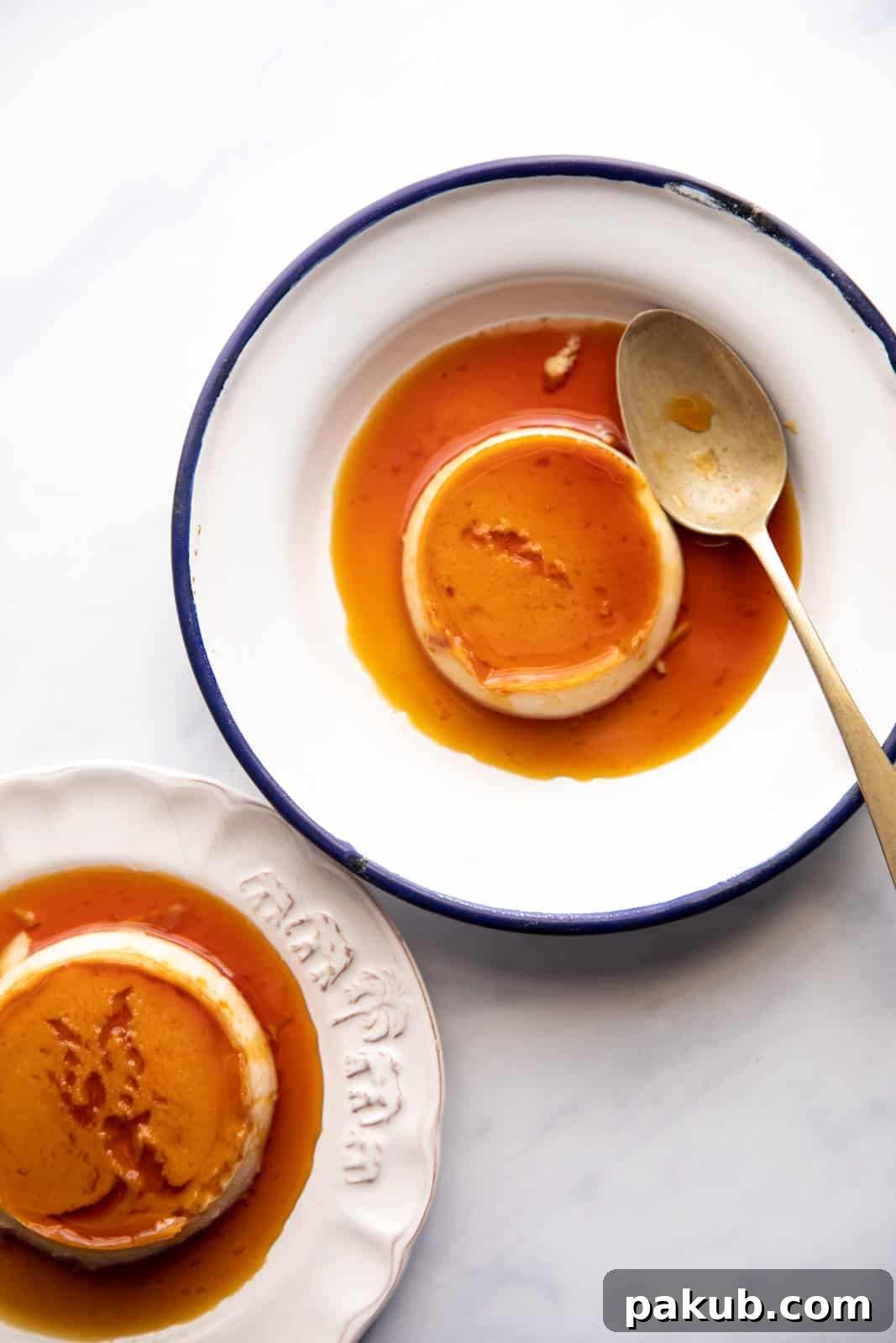 Overhead picture of two plates with coconut caramel custard ready to be served, garnished with fresh berries.