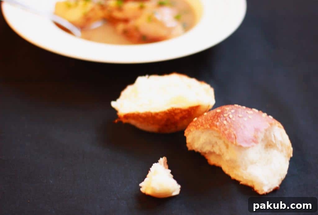 A close-up of chicken stew served with crusty artisan bread for dipping.
