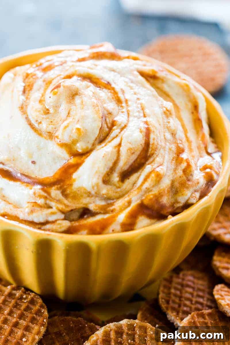 Caramel Pumpkin Pie Cheesecake Dip served in a clear bowl, with the rich caramel swirls visible, surrounded by dippers.