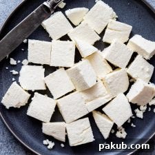 Cubes of paneer on a dark plate
