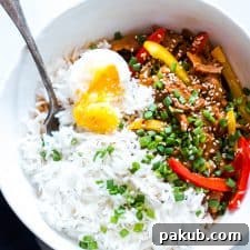 Slow Cooker Korean Pork Bulgogi with Gochujang served with egg and rice in a white bowl.