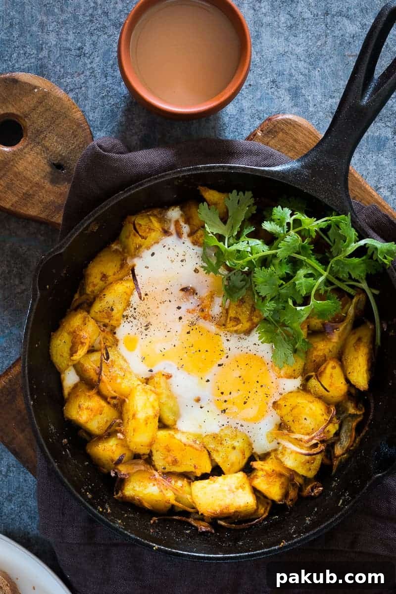 Spiced Indian Potatoes and eggs are cooked in a skillet for a hearty and easy holiday morning breakfast recipe. Perfect for a crowd, kid friendly and gluten free.
