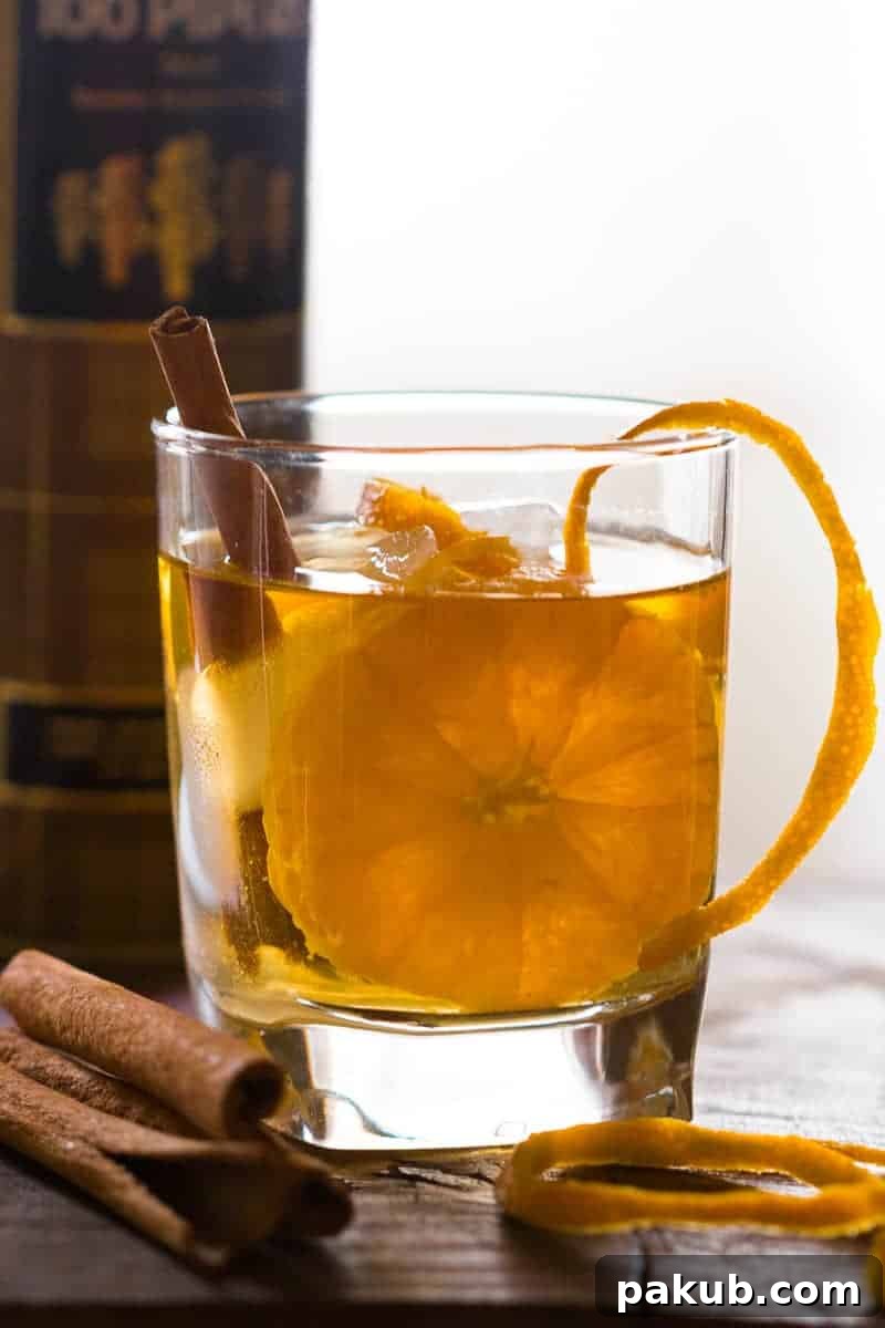 A vibrant Orange Cinnamon Whisky Smash, perfectly garnished with orange peel, ready to be enjoyed.