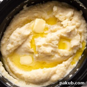 Mashed potatoes cooked and served in the slow cooker with blobs of butter on top