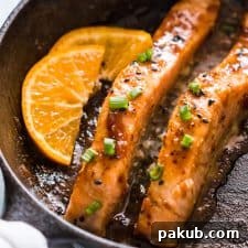 A final shot of pan-seared orange mustard salmon fillets plated beautifully with a rich, glossy sauce, ready to be enjoyed.