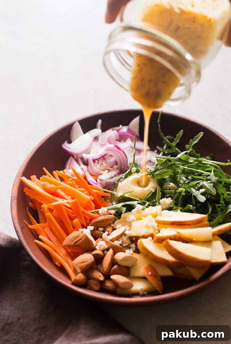 Sunshine Citrus Arugula Salad with Apples and Almonds 2 A vibrant Apple Arugula Almond Salad with Orange Dressing, presented beautifully in a bowl, showcasing fresh ingredients like crisp apples, peppery arugula, crunchy almonds, and a colorful, zesty orange dressing. This quick, easy, and healthy salad is a fantastic vegan and gluten-free option.