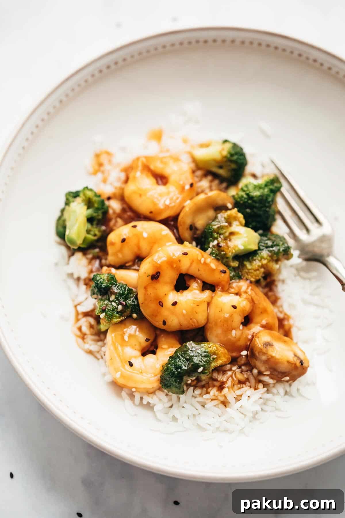 Fast Teriyaki Shrimp and Broccoli Stir-Fry 3 Teriyaki Shrimp Broccoli Stir Fry served over a bed of fluffy steamed rice, garnished with sesame seeds.