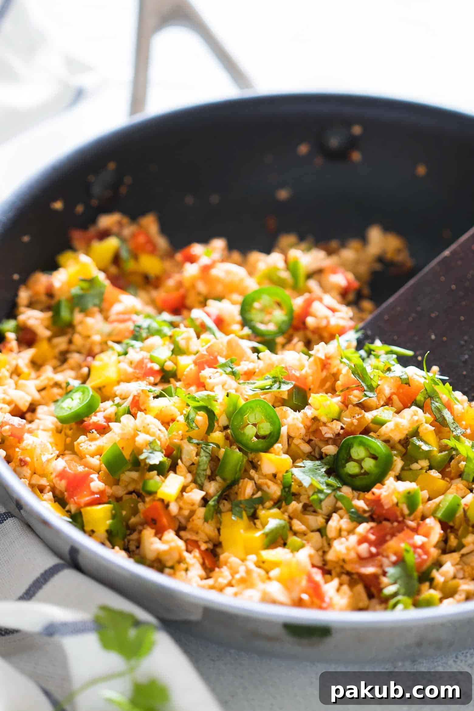 A beautifully presented bowl of Low Carb Mexican Cauliflower Rice with fresh toppings like avocado, cilantro, and sour cream, ready to eat.