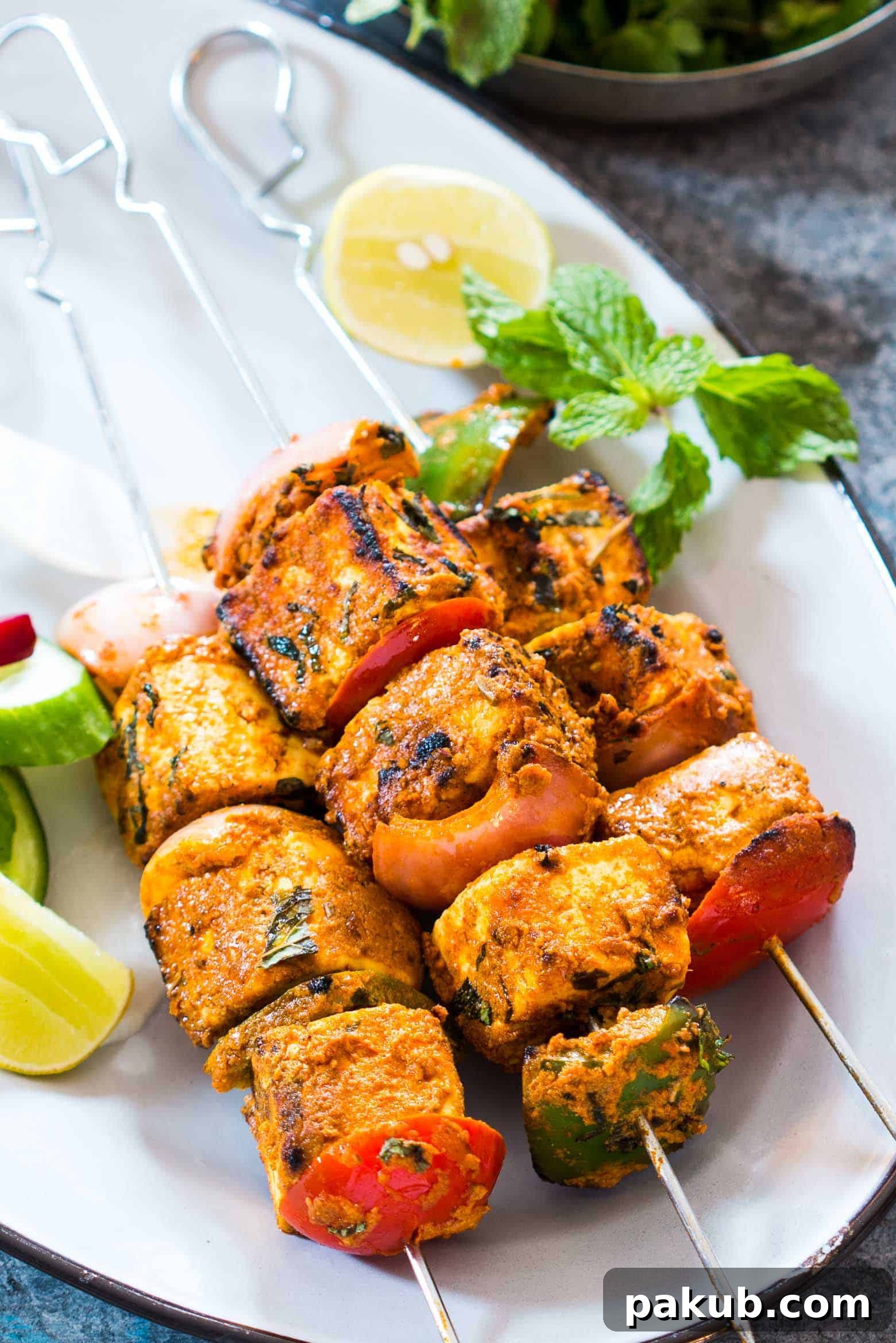 Oven-Baked Tandoori Paneer Tikka 2 Delicious Tandoori Paneer Tikka skewers, perfectly charred and roasted in the oven, ready to serve as a vegetarian appetizer or meal.