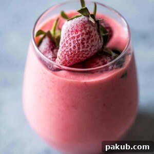 Strawberry Greek Yogurt smoothie blended till creamy and served in a glass.