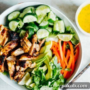 A bowl full of ingredients of the salad with a side of the dressing.