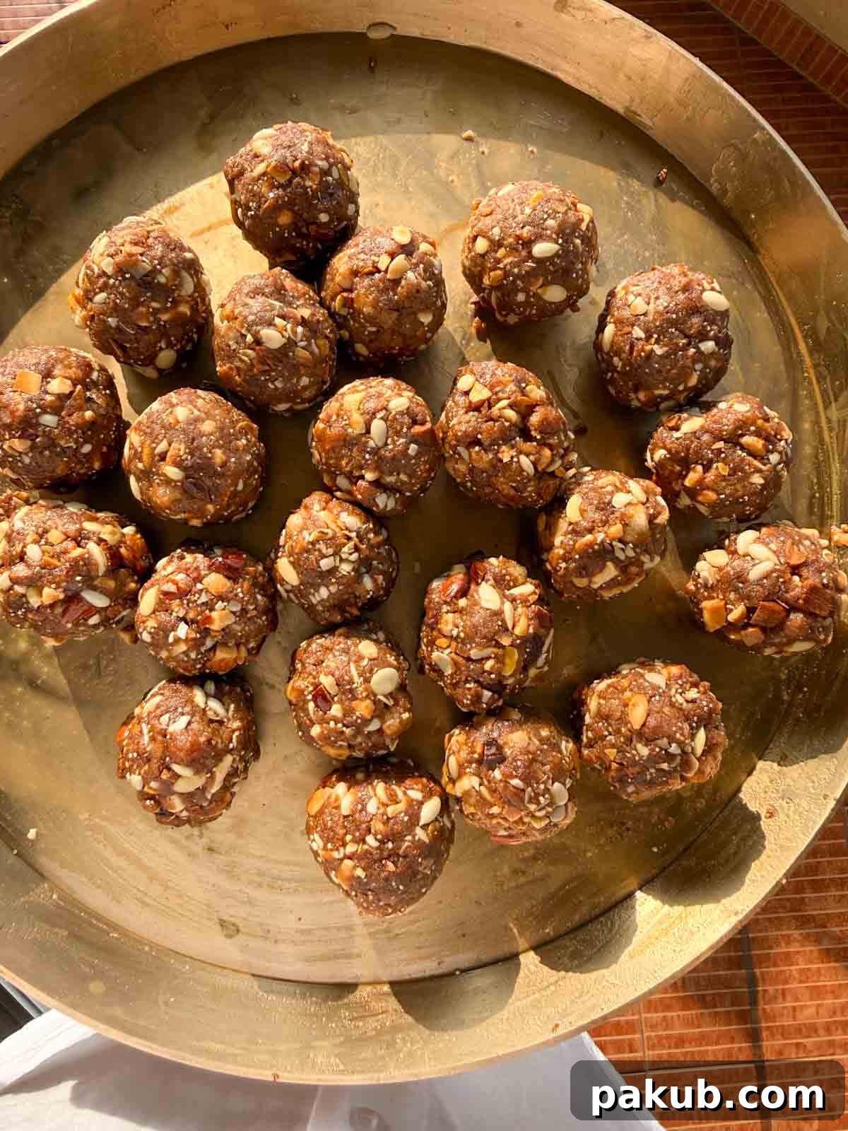 Gond ke Laddu served on a beautiful copper platter, showcasing their rich texture and golden-brown hue.