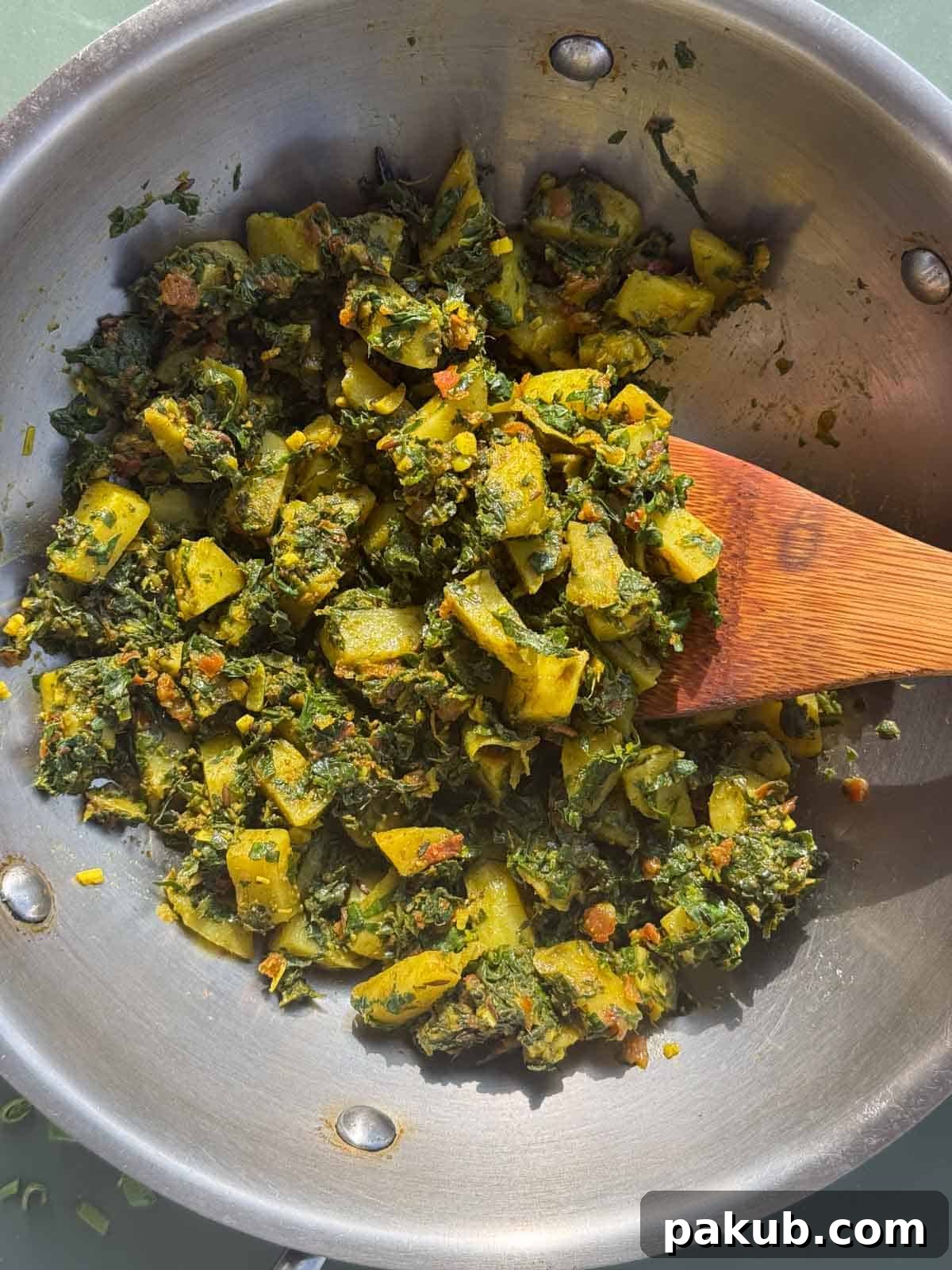 Close-up of Methi Aloo being served, with steam rising, indicating freshness