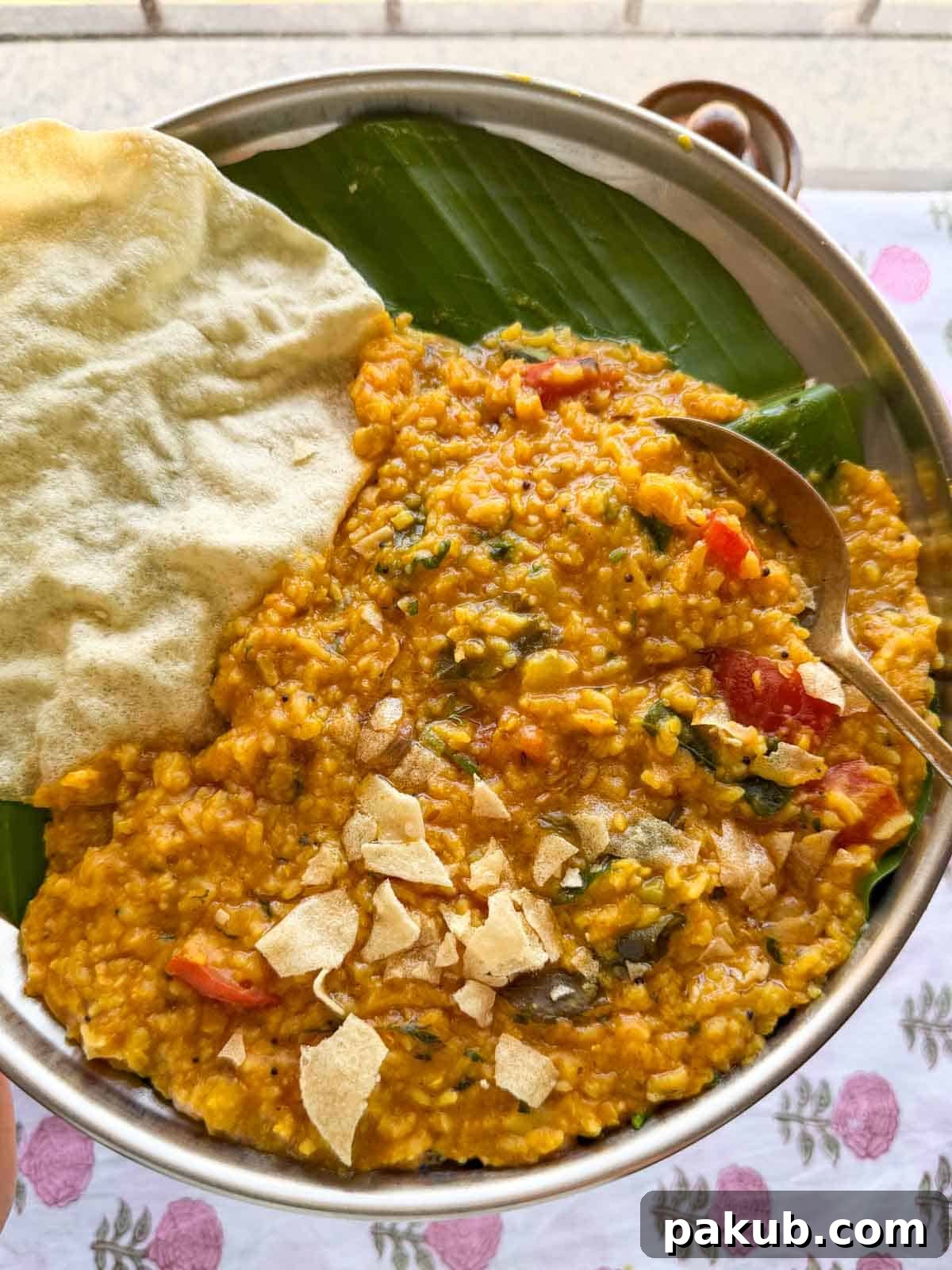 Sambar Rice served with crispy papadum and a side of cooling raita, showcasing a vibrant and comforting Indian meal.