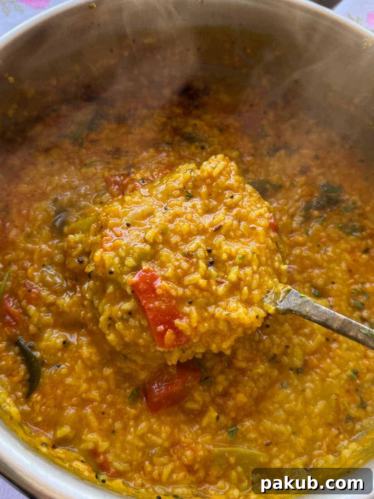 Scoop of delicious one-pot Sambar Rice from the cooking pot, ready to be plated for a hearty meal.