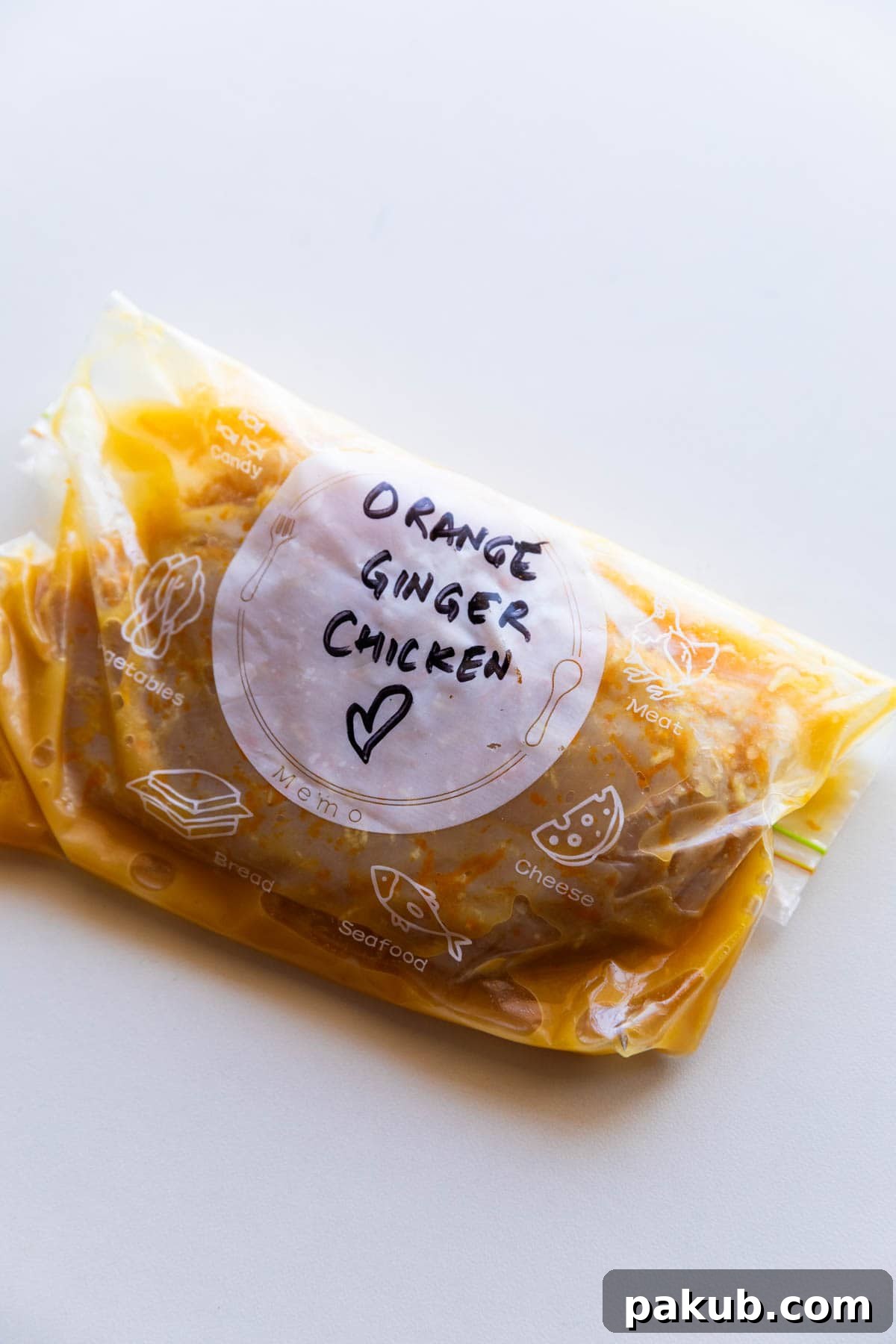 Chicken breast marinated in a bright Orange Ginger marinade, stored in a labeled zip-lock bag.
