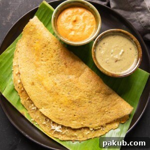 High Protein Dosa served on a banana leaf with vibrant chutney and a flavorful curry on the side, highlighting its wholesome presentation.
