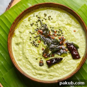 An inviting image of fresh coconut chutney, served in a bowl and beautifully placed over a banana leaf platter, a classic South Indian accompaniment.