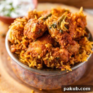 Flavorful boneless chicken biryani served exquisitely in a traditional copper handi-style bowl, inviting a delightful culinary experience.