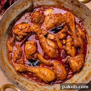 An inviting image of freshly made Nadan Chicken Curry, simmering in a traditional kadai, ready to be enjoyed.
