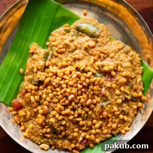 Wholesome Millet Bisi Bele Bath served on a plate lined with a banana leaf, showcasing its vibrant vegetables and comforting texture.