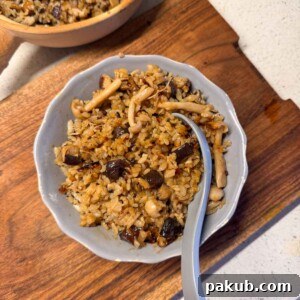 claypot mushroom rice served in a bowl with spoon