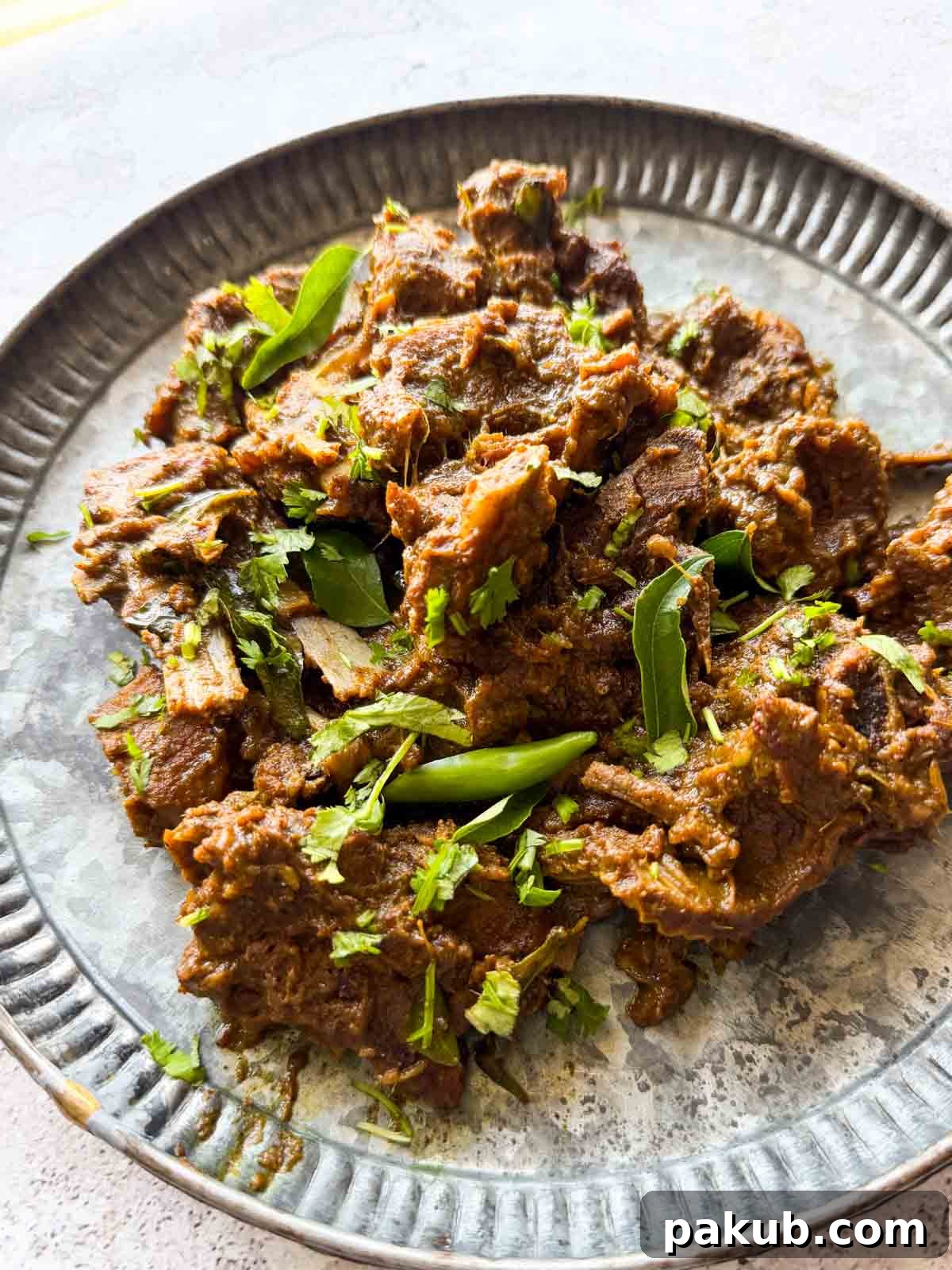 Quick & Tender Pepper Mutton Fry 2 A vibrant plate of Pepper Mutton Fry garnished with fresh coriander leaves, ready to be served.