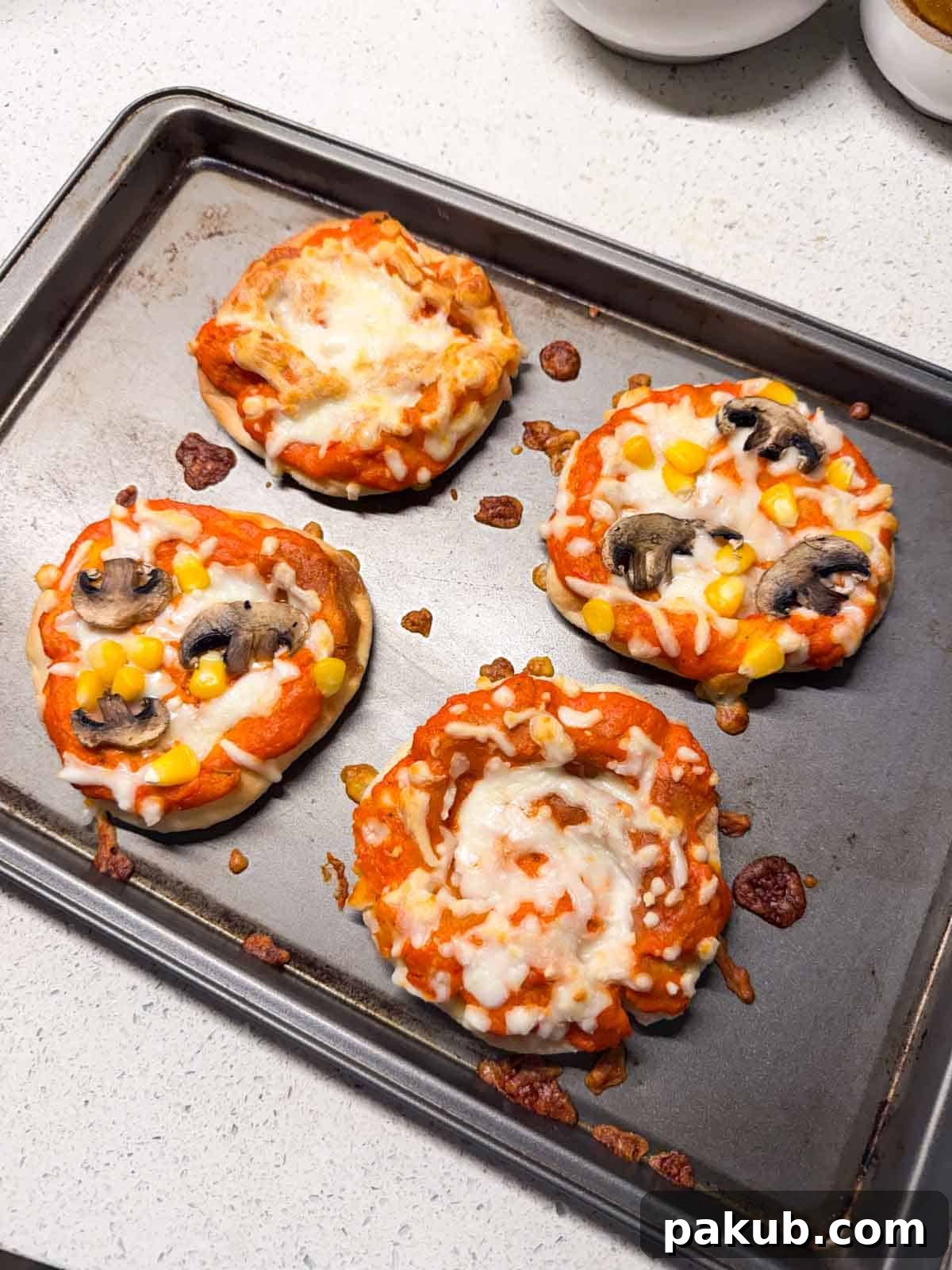 Kid-Friendly Mini Veggie Pizzas 2 Delicious homemade mini vegetarian pizzas arranged neatly on a baking tray, showcasing golden crusts and vibrant toppings, perfect for a party.