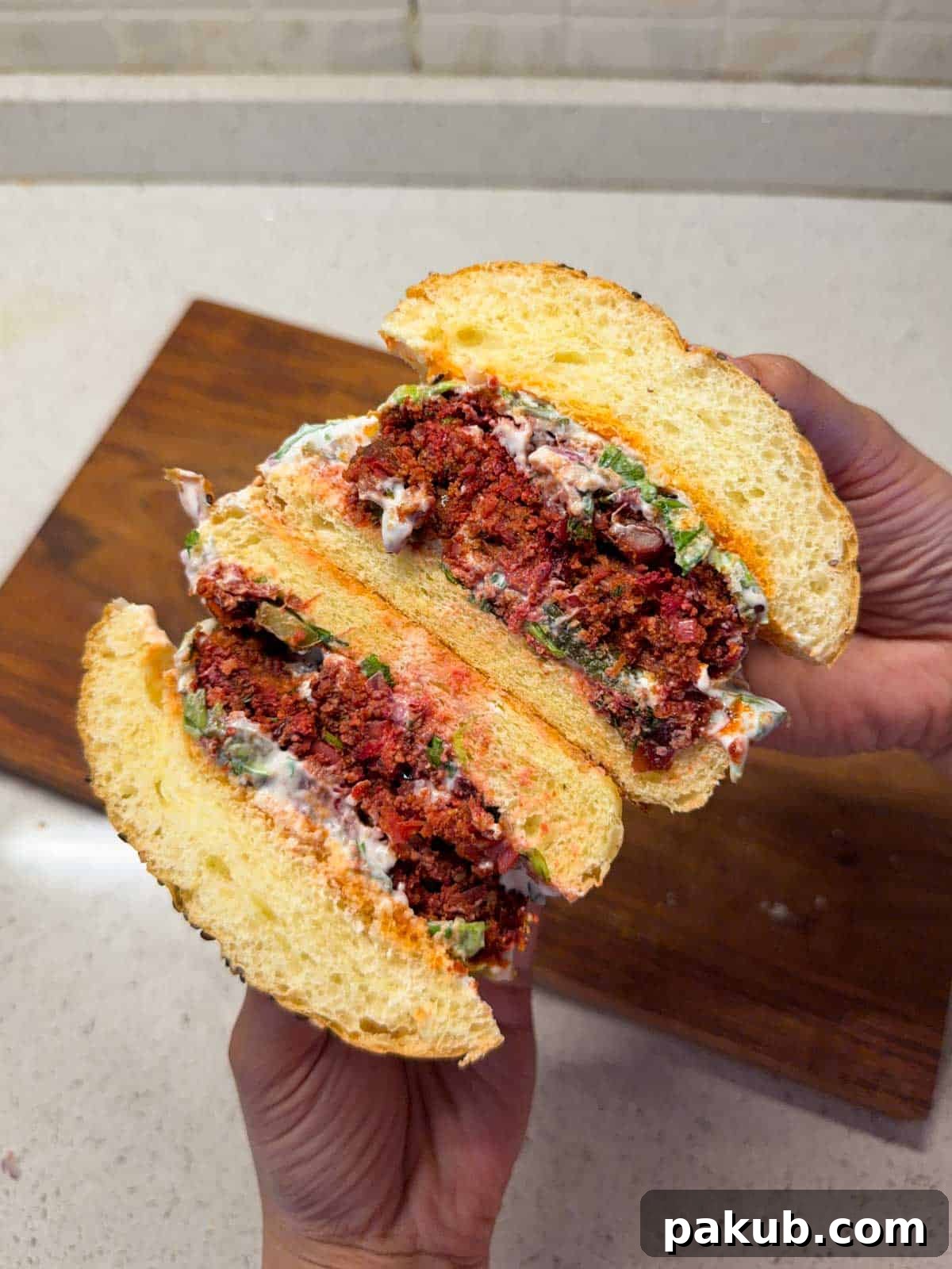A vibrant Rajma Paneer Burger cut in half, showcasing its rich texture and inviting colors.