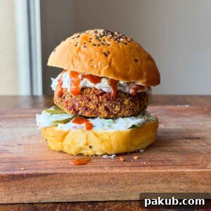 A vibrant Rajma Paneer Burger cut in half, showcasing its rich texture and inviting colors.