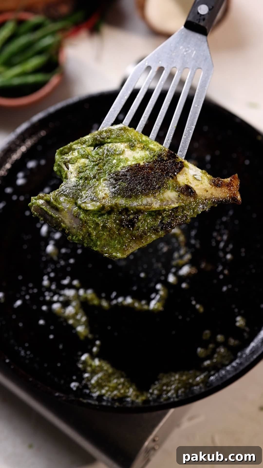pomfret fry with green masala being fried on a tawa