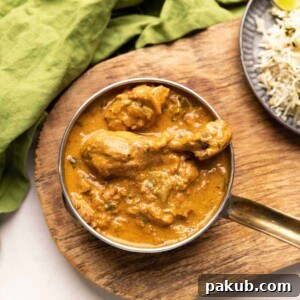 a bowl of coconut chicken curry with a side of jeera rice