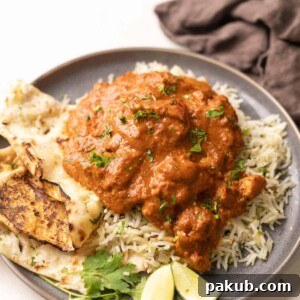 a plate of jeera rice topped with chicken tikka masala with a side of naan