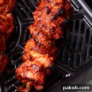 An image of freshly cooked air fryer chicken tikka still in the air fryer basket