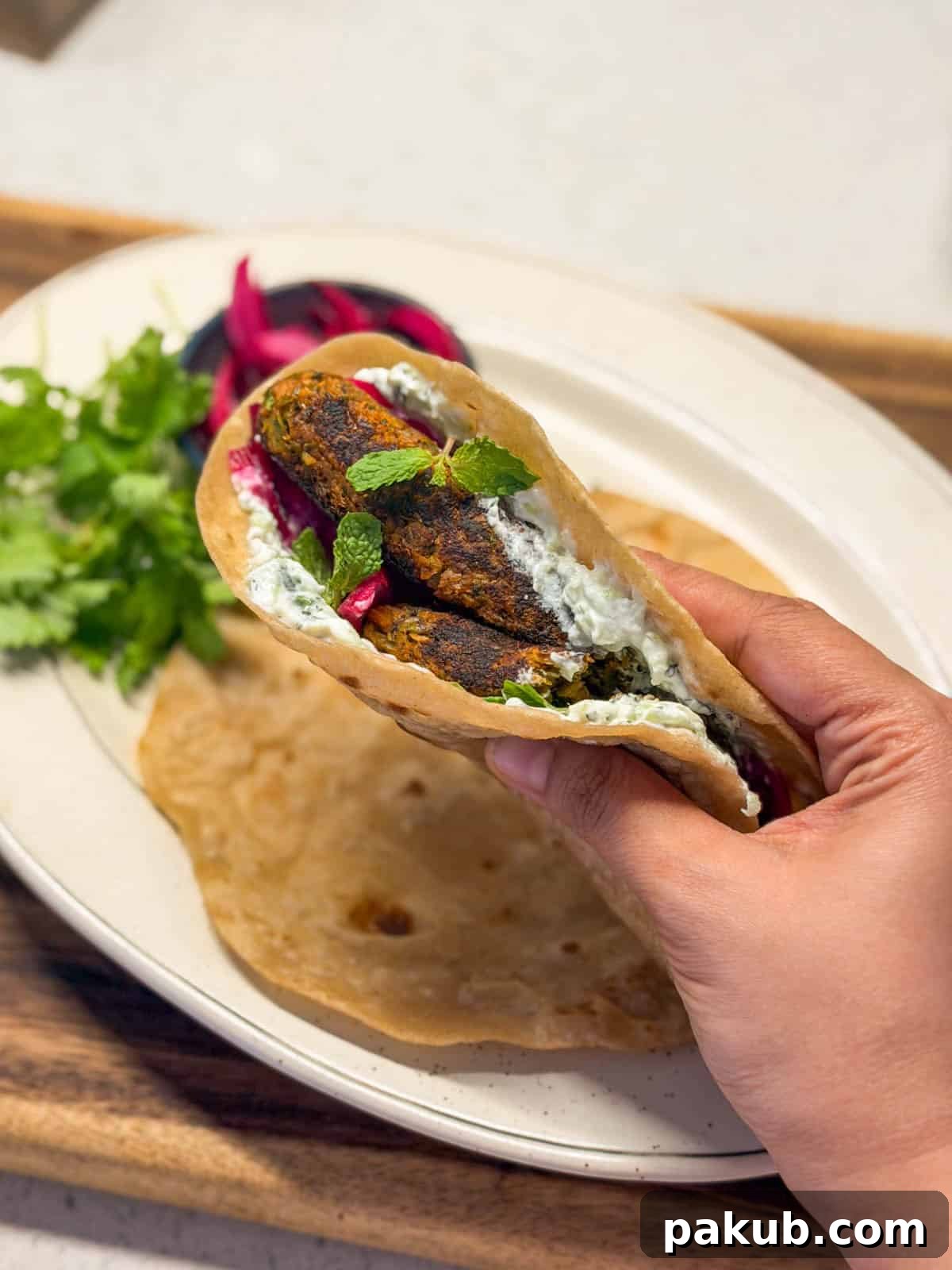 High-Protein Vegetarian Seekh Kebab Recipe for Muscle-Building 4 an image of a person holding veg a veg seekh kebab assembled in a roti