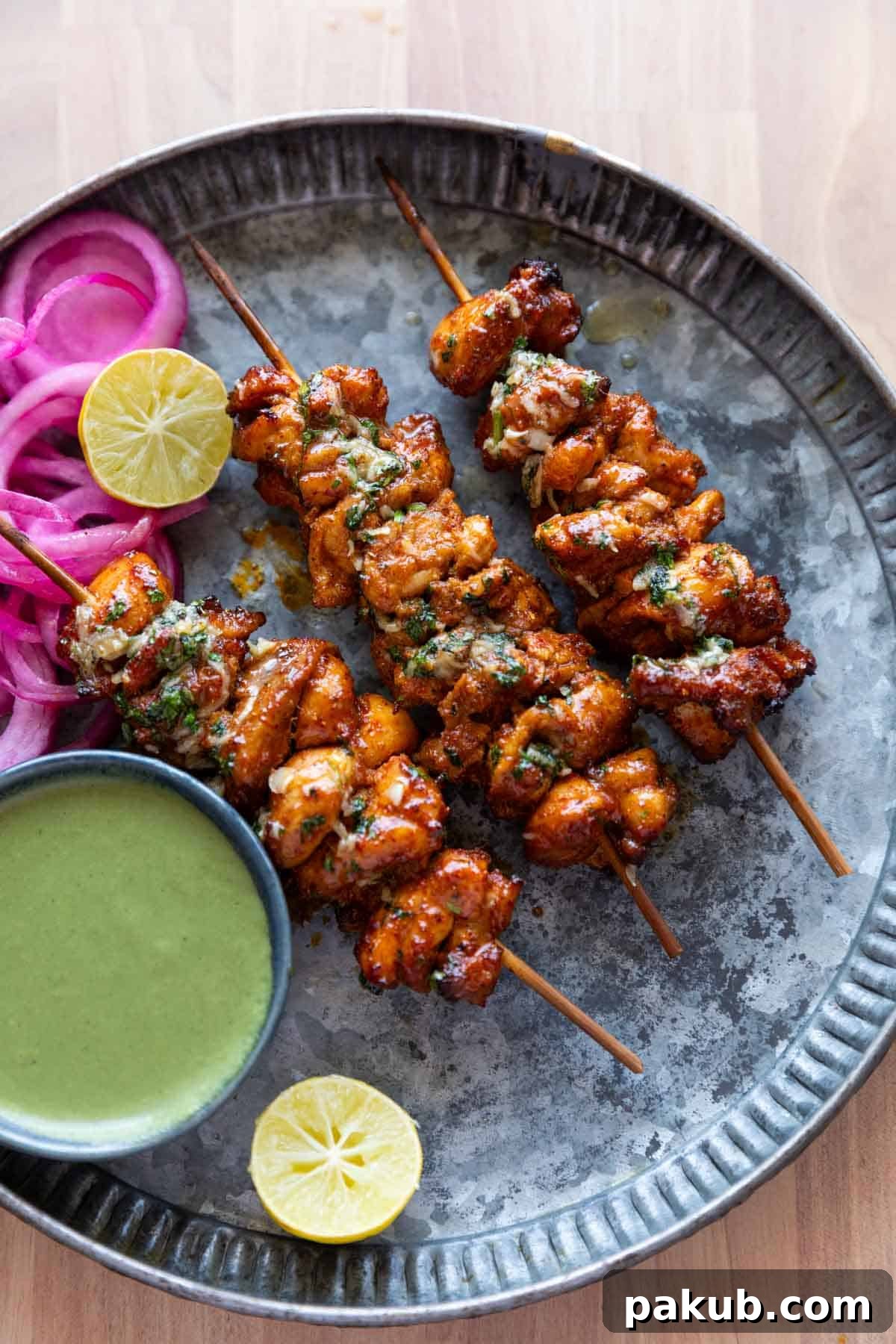 an image of achari chicken tikkas served in a plate with accompaniments
