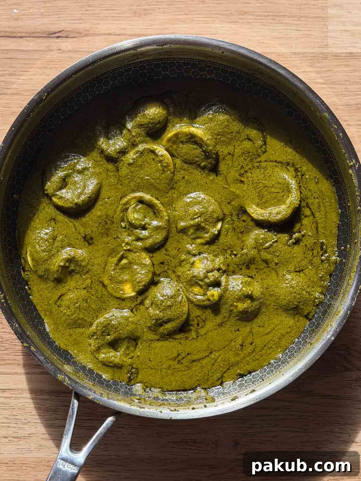 green egg curry in it's cooking vessel ready for serving