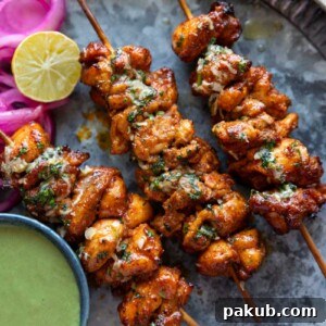an image of achari chicken tikkas served in a plate with accompaniments