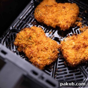 fried chicken cooking in an air fryer basket