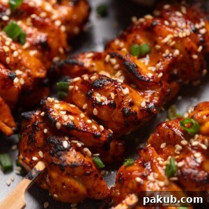 A close up image of bang bang chicken skewers to showcase their crispy, smokey texture