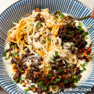 freshly made creamy chilli noodles in a bowl along with a fork