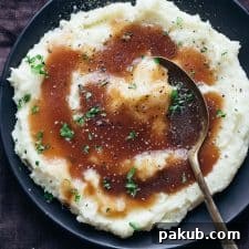 Brown vegetarian gravy poured on mashed potatoes