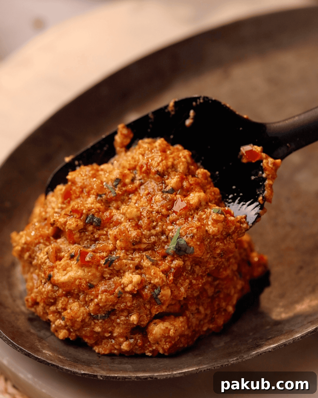 Amritsari paneer bhurji being served on a plate with a ladle